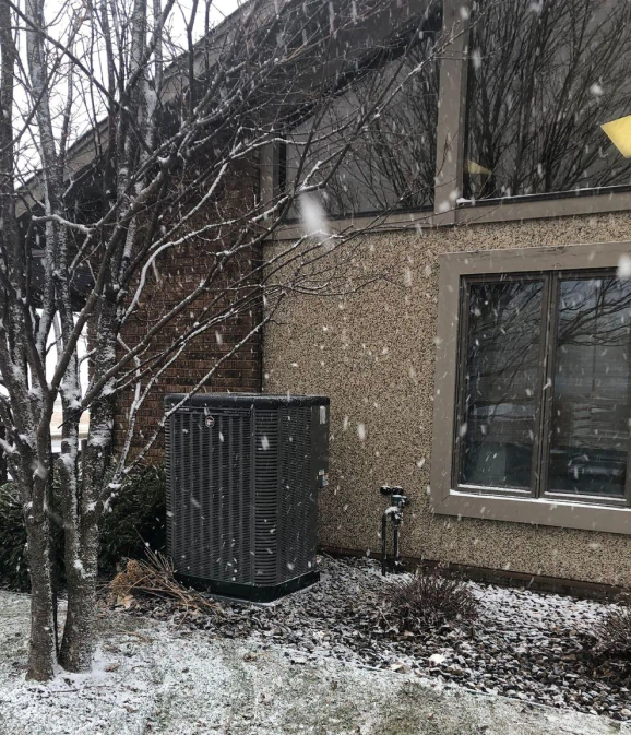 hvac unit at back of snowy residential house